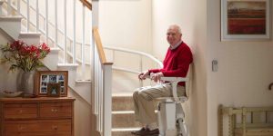 an old man sitting on a stairlift