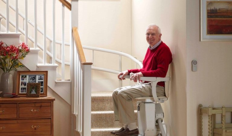 an old man sitting on a stairlift