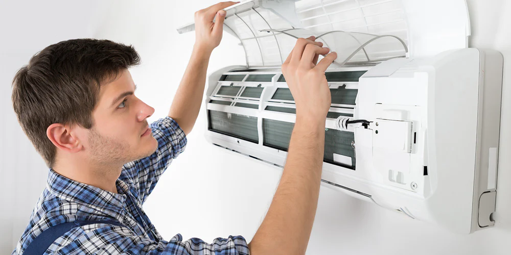 a man opening the air conditioner and cleaning