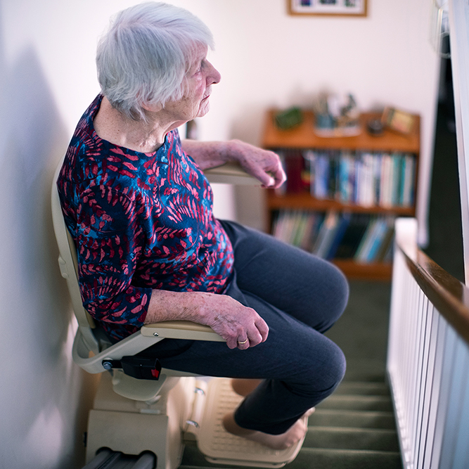 young woman sitting on a stairlift 